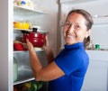 Woman putting pan into refrigerator Royalty Free Stock Photo