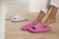 Woman putting on pink slippers indoors, closeup Royalty Free Stock Photo