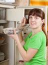 Woman putting raw frozen fish into refrigerato Royalty Free Stock Photo