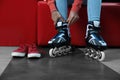 Woman putting on roller skates indoors Royalty Free Stock Photo