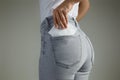 Woman putting sanitary pad into jeans pocket