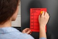 Woman putting shopping list on refrigerator door Royalty Free Stock Photo