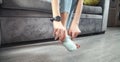 Woman putting socks while sitting in couch