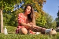 a woman putting sunscreen on body sitting on grass Royalty Free Stock Photo