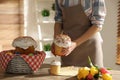 Woman putting traditional Easter cakes in basket indoors, closeup Royalty Free Stock Photo