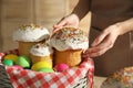 Woman putting traditional Easter cakes in basket indoors, closeup Royalty Free Stock Photo