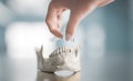 The woman is putting a transparent orthodontic aligner on a cast of teeth using her hand