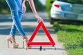 Woman putting a triangle on a road