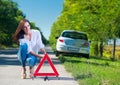 Woman putting a triangle on a road