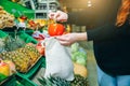 Woman is putting vegetables in reusable shopping bag. Ecologically and environmentally friendly packets. Canvas and linen fabrics Royalty Free Stock Photo