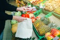 Woman is putting vegetables in reusable shopping bag. Ecologically and environmentally friendly packets. Canvas and linen fabrics Royalty Free Stock Photo
