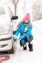 Woman putting winter tire chains car wheel Royalty Free Stock Photo