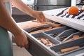 Woman putting wooden spoon into kitchen drawer Royalty Free Stock Photo