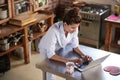 Woman in pyjamas stands using laptop in kitchen, high angle Royalty Free Stock Photo