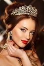 Woman queen princess in crown and lux dress, lights party background Luxury girl Long shiny healthy volume hair Waves Curls