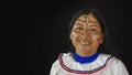 Woman of the Quichua ethnic group of the Ecuadorian Amazon smiling from the front in her traditional dress on a black background