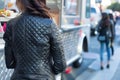 woman in a quilted leather jacket waiting in line at a food truck Royalty Free Stock Photo