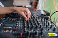 Woman radio DJ plays music at radio station studio on mixing console, hand close-up.