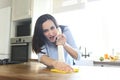 Woman with rag and spray bottle cleaning wooden counter-top Royalty Free Stock Photo