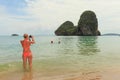 Woman at Railay beach taking a photo