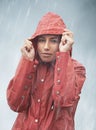 Woman, rain and portrait with storm, raincoat and safety with protection in nature. Person, face and weather with cloudy Royalty Free Stock Photo