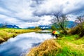 Woman with a rainbow colored Umbrella under dark rain clouds on a cold spring day at the lagoons of Pitt-Addington Marsh Royalty Free Stock Photo