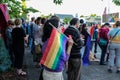 Woman with rainbow flag in crowd gives peace sign to passing motorists Royalty Free Stock Photo