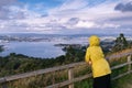 Woman with a raincoat looking at thje beautiful landscape of a estuary