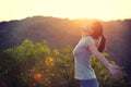 woman raised arms to sunrise on mountain top in the moring