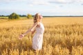 Woman raising arms enjoying sunlight in field . Portrait of young girl Royalty Free Stock Photo