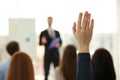 Woman raising hand to ask question at business training indoors, closeup