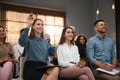 Woman raising hand to ask question at seminar in office Royalty Free Stock Photo