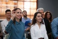 Woman raising hand to ask question at seminar in office Royalty Free Stock Photo