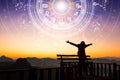 Woman raising hands looking at the sky. Astrological wheel projection, choose a zodiac sign. Trust horoscope future predictions,