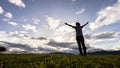 A woman raising her arms at sunset. A young woman at sunset raises her hand and prays for a blessing from God Royalty Free Stock Photo