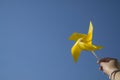 A woman raising her hand with yellow pinwheel to sky. Copy space. Handmade toy Royalty Free Stock Photo