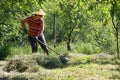 Woman raking the grass into a pile. Farm chores, working on a field and raking the grass Royalty Free Stock Photo