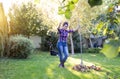 Woman raking leaves in garden