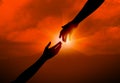 Woman reaching for man`s hand at sunset. Help concept Royalty Free Stock Photo