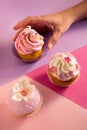 Woman reaching out to take cupcakes