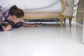 Woman Reaching Towards Slippers Under Bed