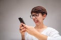 Woman reacting in revulsion to her mobile phone Royalty Free Stock Photo