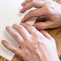 Woman read book with braille by fingertips closeup