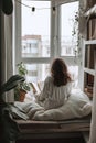 Woman read book, A cozy minimalist reading nook with natural light.