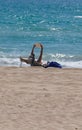 A woman read a book while sunbathing in El Arenal beach in Mallorca vertical