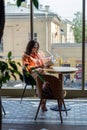 Woman Reading Book in Cafe over Big Window