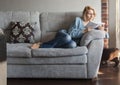 Woman reading a book on the couch Royalty Free Stock Photo