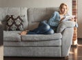 Woman reading a book on the couch Royalty Free Stock Photo