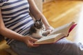 Woman reading book and cuddling kitten Royalty Free Stock Photo