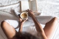 Woman reading a book and drinking coffee on bed with socks Royalty Free Stock Photo